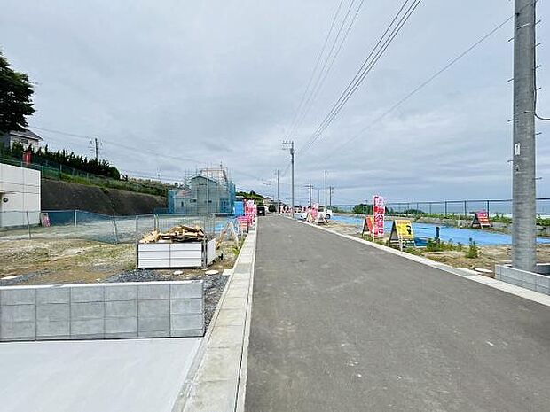 前面道路が広く確保されており車の出し入れもスムーズに行えます。周囲は開放感のある雰囲気で現地の状況も分かりやすい写真です。全体的に整備が進んでいる様子が確認できます。ゆとりある前面道路が特徴です。