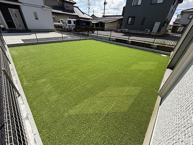 広々とした庭が特徴的です。開放感のある空間が魅力で手入れのしやすい人工芝が広がっています。陽当たりも確保されていますので多目的に利用できます。明るい印象を与える庭です。