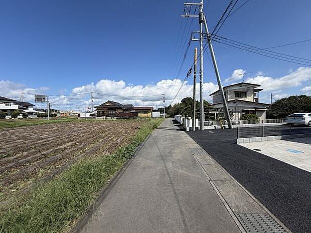 広々とした前面道路が印象的で周囲には開放感のある景観が広がっています。幅のある道路のため車の出入りもしやすい印象です。晴れた日の青空がより一層現地の魅力を引き立てます。