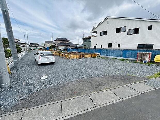 ゆとりある敷地で駐車スペースも確保されています。周囲は住宅が建ち並ぶ静かな環境です。建築中の様子が分かる現地写真となっています。前面道路も整備されています。