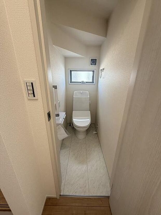 シンプルで落ち着いた色合いのトイレです。小窓が付いているため換気がしやすくなっています。室内は清潔感がありお手入れも簡単そうです。スペースを有効に活用した設計となっています。