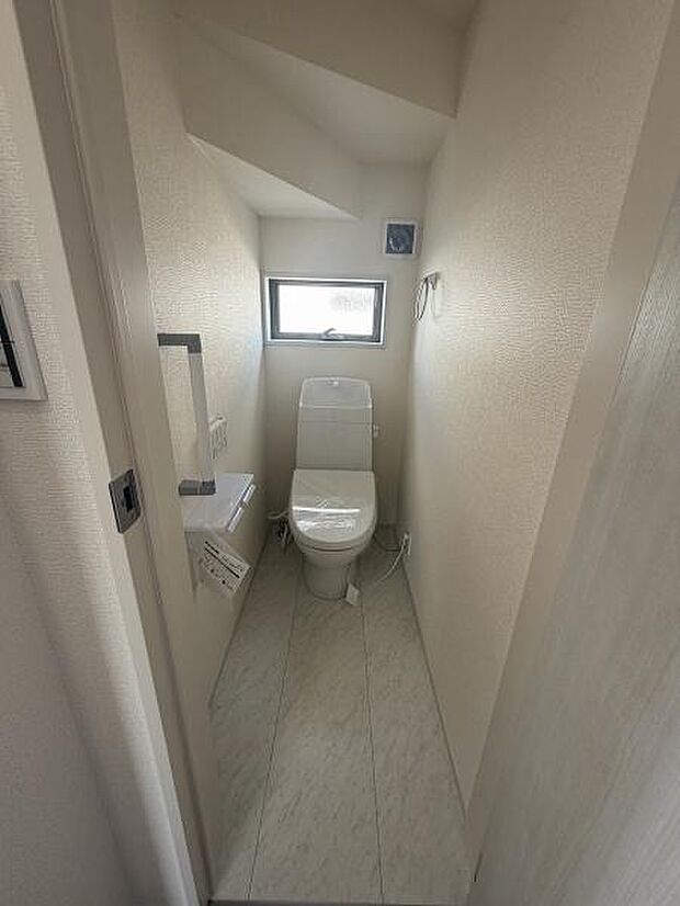 コンパクトなスペースながらトイレには明るい採光窓が設けられています。手すりも備え付けられており使いやすさが感じられます。落ち着いた色調の内装で清潔感があります。換気がしやすい設備です。