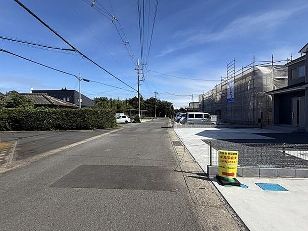 前面道路は広く車の出入りがスムーズに行えます。周囲は落ち着いた住宅街で静かな環境が整っています。工事中の建物や駐車スペースが確認でき整然とした雰囲気が感じられます。青空が広がり日当たりも期待できます。