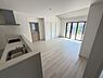 リビング/ダイニング：リビングには大きな窓があり明るい日差しが差し込みます。ナチュラルなフローリングが空間を広く感じさせます。キッチンとの一体感があり使い勝手のよいレイアウトです。収納スペースも確保されています。