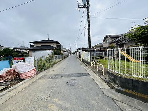 前面道路はゆったりとした幅があり車の通行にも安心感があります。周囲は住宅街で落ち着いた雰囲気が漂います。敷地前はフェンスでしっかり区切られており周辺の環境も整っています。