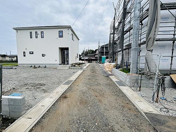 前面道路が広く取られており車両の出入りがしやすい現地写真です。住宅が整然と並んでいる印象です。新築物件や建築中の建物が確認でき周辺環境の変化を実感できます。閑静な印象も感じられるエリアです。