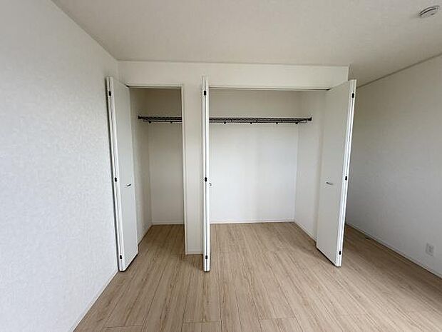 シンプルなデザインの収納スペースです。扉が大きく開くため出し入れがしやすい仕様です。床から天井までしっかりと高さがありロッドも備え付けられています。内部も広々としておりすっきりとした印象です。
