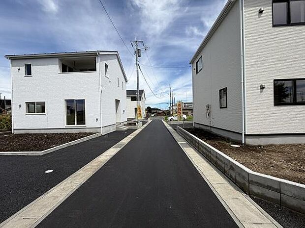 前面道路は幅も十分にあり車の出入りがしやすい設計です。新しい舗装が印象的で歩行や車の移動も快適に行えます。両側の建物も整然と並び景観がすっきりとしています。
