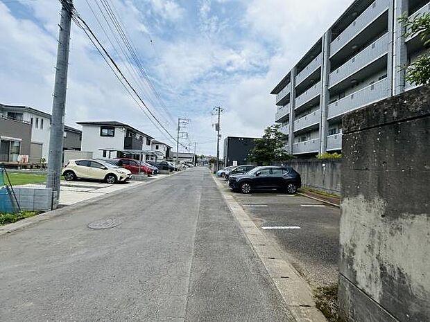 前面道路が広く車の出し入れがしやすい環境です。道路沿いには整然とした住宅やマンションが並びすっきりとした街並みが広がっています。側道には駐車スペースが設けられ生活利便性が感じられます。