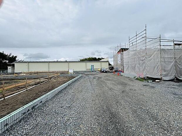 広々とした前面道路が魅力的な現地写真です。車の出入りがしやすくアクセスもスムーズです。周囲がすっきりと整備された現地の様子がわかります。造成中のため開放感があります。工事の進行状況も確認できます。