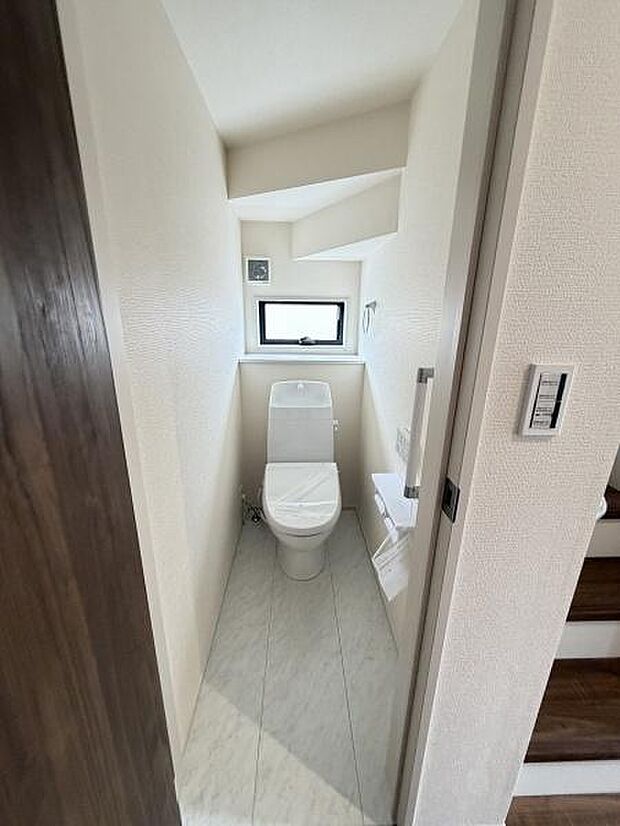 シンプルな内装で清潔感を感じられるトイレです。小窓があり明るい自然光が差し込みます。空間が効率的に活用されています。コンパクトな中にも機能性が考えられています。