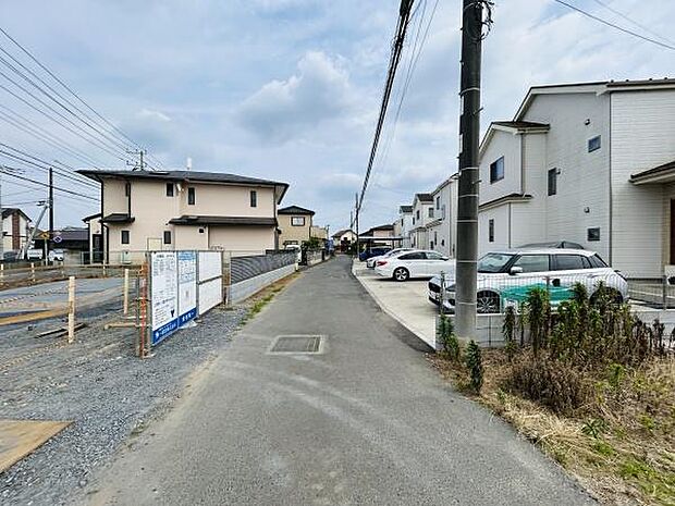 前面道路は車の通行がしやすい幅員を確保しています。周囲には新しい住宅が整然と並んでいます。現地はゆったりとした区画に位置しています。道沿いには駐車スペースも設けられています。