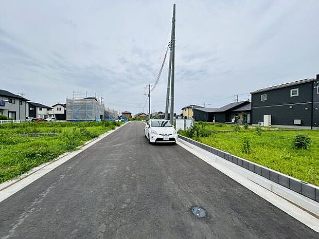 幅広い前面道路が確保されており車の出し入れもスムーズに行えます。周辺は新しい住宅が立ち並び整然とした街並みが広がっています。道路沿いには緑地スペースがあり開放感のある印象です。