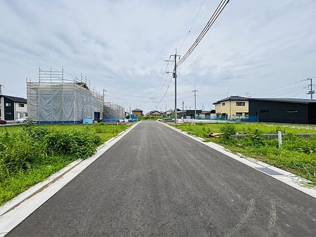 前面道路は幅が広く車の出入りやすれ違いがしやすい造りです。周辺には新しい住宅が建設中で街並みに整然とした印象があります。電柱や配線が整備されておりインフラ面も確認できます。