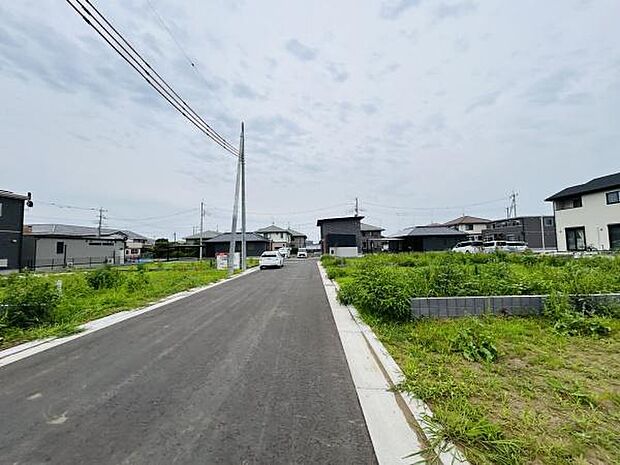 前面道路がしっかり整備されており開放感を感じられる現地写真です。車の出入りもスムーズに行えそうです。周辺には新しい住宅が建ち並んでいます。道路幅にも余裕がありゆったりとした印象です。