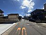 その他：現地前面道路の様子がよくわかる写真です。周辺に住宅が建ち並んでおり車の通行にも配慮された環境です。日当たりの良さが印象的で空が広く感じられます。道路の幅も十分に確保されています。