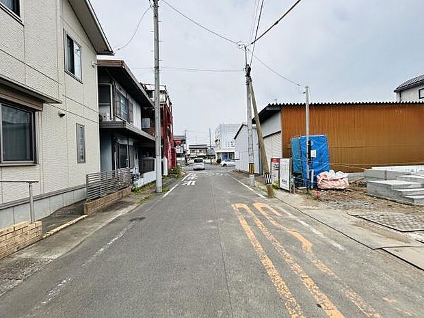 前面道路は幅員が確保されており見通しの良い直線道路です。周辺には住宅や建物が整然と並び落ち着いた雰囲気です。舗装もしっかりしているため日々の通行も安心です。静かな住宅街の一角に位置しています。