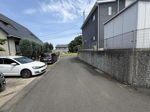現地前面道路は車の通行がしやすい幅となっております。周囲には住宅が立ち並び落ち着いた街並みが特徴です。舗装された道路と整った歩道が快適な日常をサポートします。現地の様子が分かりやすい写真です。