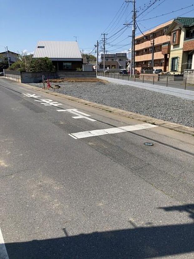 前面道路が広く車の出入りがしやすい環境です。周辺には住宅が並び落ち着いた印象のエリアとなっています。舗装された道路が続いておりアクセスも便利です。現地の様子がよくわかる写真です。