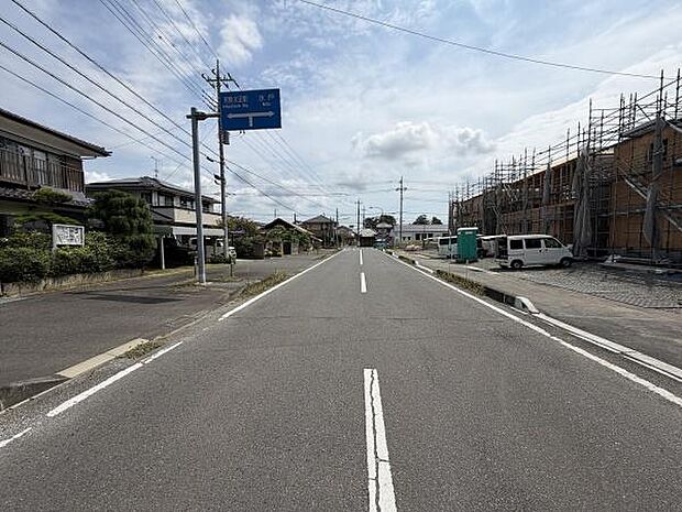 前面道路は幅が広く車の通行もしやすい道路環境です。周囲には住宅や新築物件が並び落ち着いた雰囲気が感じられます。歩道も整備されており安全面にも配慮されています。電線や標識などのインフラも整っています。