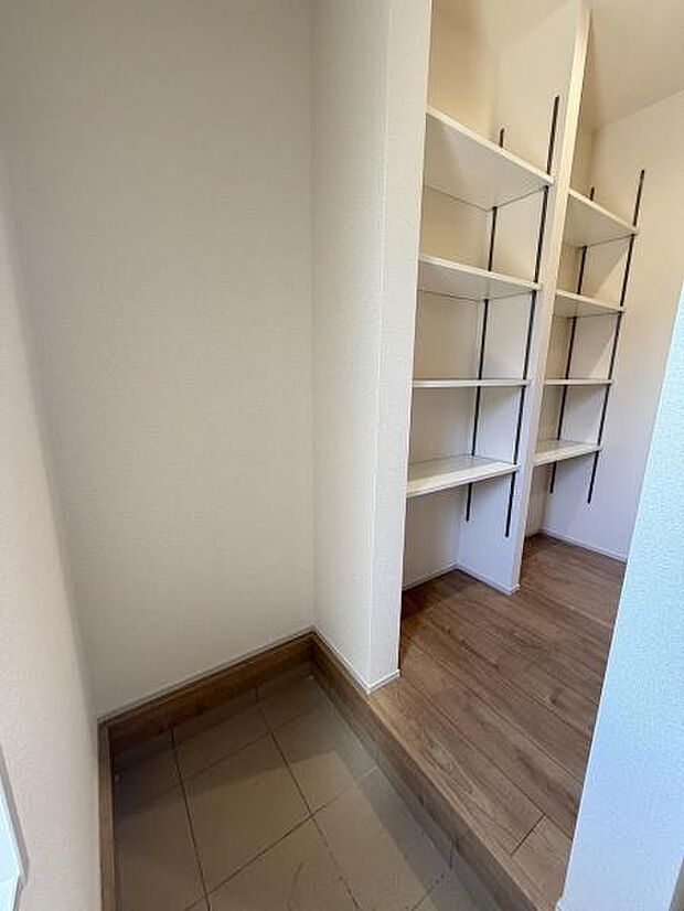 玄関には可動式の棚が設置されており整理整頓がしやすい空間です。土間部分とフローリングがしっかり分かれているため用途に応じて使い分けが可能です。明るい内装が清潔感を感じさせます。