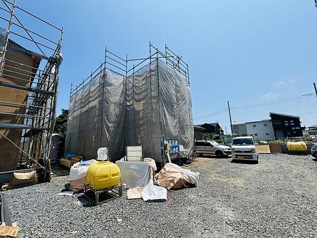 建設中の建物がしっかりと養生されている様子が伝わります。ゆとりある敷地が広がり資材の配置も整っています。快晴の空の下明るい敷地が印象的です。車の乗り入れもスムーズにできそうです。