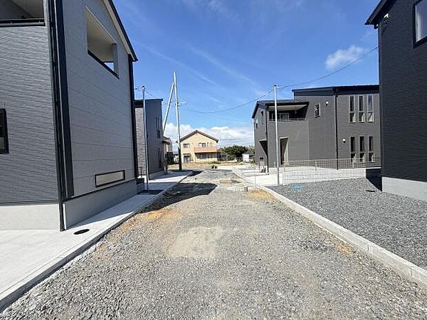 前面道路を含む現地写真です。周囲には新築住宅が建ち並び街並みが整っています。開放感があり明るい印象を受けます。道路幅もあり車の通行にも配慮されています。