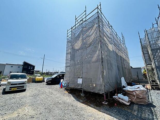 建築中の現場がしっかりと確認できる写真です。周囲は開放的な印象で駐車スペースも確保されています。作業資材がきちんと管理されており整理整頓が行き届いています。