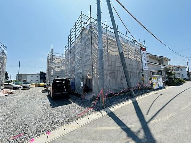 現在建築中の物件で外観全体に足場と養生シートが設置されています。日当たりが感じられる角地に位置しており周囲は開けた印象です。複数台の車の駐車スペースも確保されています。