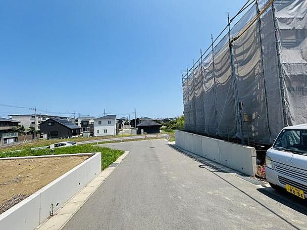前面道路は幅員が広く見通しも良好です。現地周辺は閑静な住宅エリアで落ち着いた雰囲気が感じられます。道路沿いには新築の建物や開放的な空き地も広がっています。車の出入りもスムーズに行える環境です。
