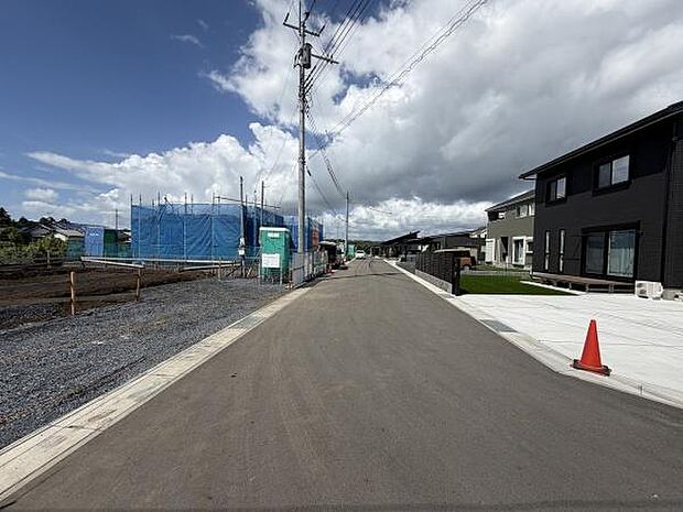 前面道路は十分な幅員があり車の出入りもスムーズです。周囲には新しい住宅が建設中で地区の発展が感じられます。歩道も整備されており安心して利用できます。空の広がりと開放感も魅力です。