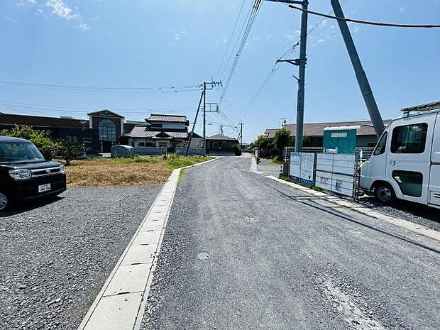 現地の前面道路はゆとりある道幅が確保されており車の出入りもスムーズに行えます。周囲は静かな住宅街が広がり整備された舗装道路が印象的です。日当たりもしっかり感じられる現地写真です。