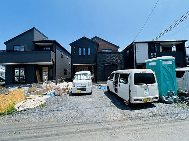 シャープな外観が印象的な新築住宅です。黒を基調としたデザインが落ち着いた雰囲気を演出しています。二階建てでバルコニーもあり開放感があります。駐車スペースも広めに確保されています。
