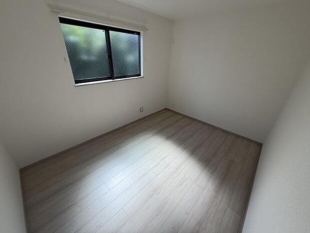 シンプルな内装が特徴の洋室です。窓から自然光が入り室内が明るい印象となっています。床材は落ち着いた色合いでさまざまなインテリアと調和しやすいです。