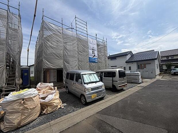 建築中の物件で完成後の新しさを感じられる現場写真です。前面道路が広く車の出し入れがしやすそうです。平坦な土地で周囲も静かな住宅地に位置しています。建築現場の様子がしっかり確認できます。