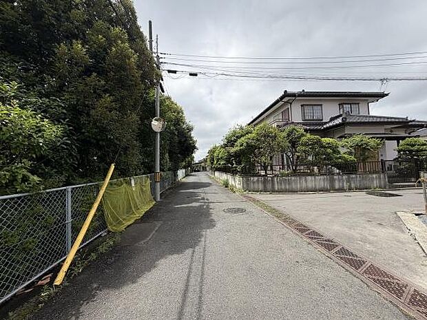 前面道路は幅がしっかり確保されており車の出入りがしやすい印象です。道路沿いには緑が多く落ち着いた雰囲気が感じられます。周辺は住宅街で静かな環境が広がっています。舗装された道路なので移動も快適です。