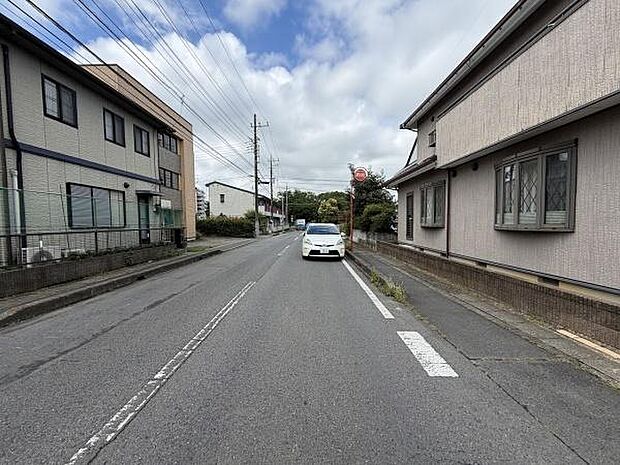 前面道路がしっかり整備されており車の通行もスムーズに行えます。周囲には住宅が並び落ち着いた雰囲気が感じられます。視界を遮るものが少なく見通しの良い道路です。