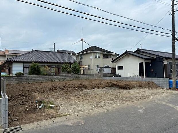 現地は敷地が整地されている状態です。前面道路は舗装されており車両の出入りもスムーズです。周囲には住宅が建ち並び落ち着いた雰囲気です。