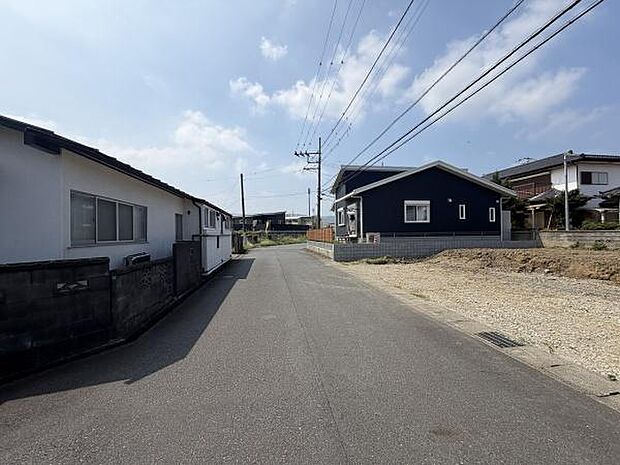 前面道路は幅があり車の出入りもスムーズです。周囲は落ち着いた住宅が並んでいます。空が広く見渡せる開放感のある現地です。物件周辺は整然とした街並みが広がっています。