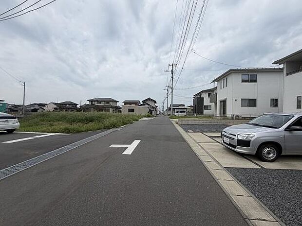 周辺には住宅が整然と並び落ち着いた雰囲気が感じられます。前面道路は広めで車両の出入りもスムーズです。視界が開けており見通しが良い道路です。電線が整理されているため空を広く感じられます。