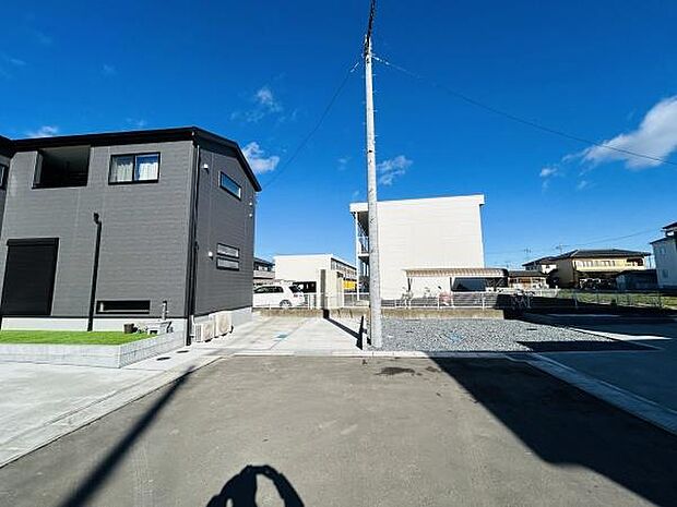 開放感のある現地写真で周囲の建物や空の広がりも感じられます。前面道路が広く日当たりも良好です。現地の様子がしっかりと確認できる一枚です。車の出入りもスムーズに行えそうです。