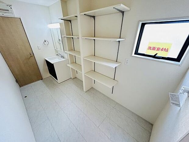 収納棚が壁一面に設けられており整理整頓に便利です。明るい空間で清潔感があります。水まわりに近い場所に棚があり使い勝手も良好です。換気がしやすい窓も設置されています。
