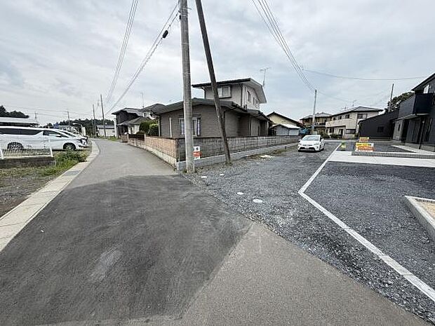 現地写真にて周辺の落ち着いた住宅街の様子が確認できます。前面道路は道幅があり見通しも良好です。住宅や車の配置も分かりやすい現地の状況がしっかり伝わります。歩道が整備されている点もポイントです。