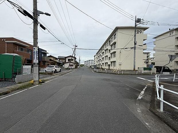 前面道路は幅が広く車のすれ違いもスムーズに行えます。周辺には集合住宅や住宅が並び落ち着いた街並みが広がっています。電柱や標識などインフラも整備されており安心して利用できます。