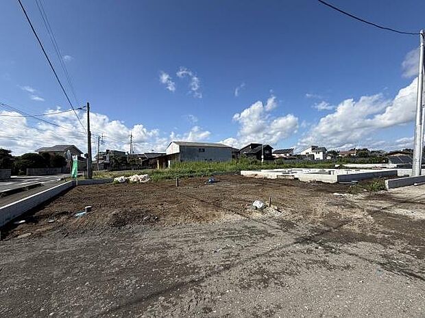 広々とした土地が特徴的な現地写真です。周囲には住宅が点在し開放感のある空間が広がっています。インフラの整備も進んでおり建築を検討する際にも安心です。空の広さが印象的で自然光がしっかりと差し込みます。