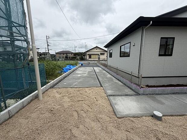 広々とした駐車スペースが確保されています。コンクリート舗装されておりゆとりのある設計です。車の出し入れもスムーズに行えるような直線的な配置です。周囲の境界が明確で安心してご利用いただけます。