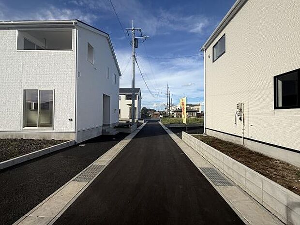前面道路が広く車の出し入れがしやすい現地写真です。両側に整然とした住宅が並び清潔感のある街並みが印象的です。周辺環境も整備されており快適に暮らせるエリアとなっています。