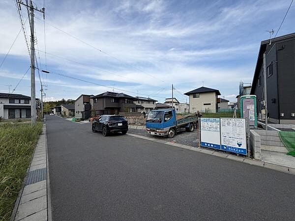 現地前面道路は広々としておりゆとりある通行が可能です。周囲には新しい住宅が並び落ち着いた雰囲気が魅力です。建設中のため将来的な街並みの変化も期待できます。