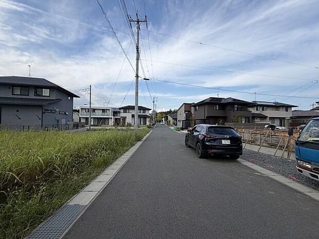 前面道路は広々としており車の出入りも安心して行えます。周辺には新しい住宅が並び整然とした街並みが広がっています。道路の両側は見通しが良く開放感が感じられます。電柱や配線もすっきりと配置されています。