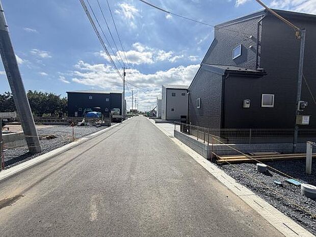 前面道路は広々とした印象で開放感のある環境です。周囲には新しい建物が並びすっきりとした街並みが広がっています。現地周辺は整った舗装が施され歩行や車の移動もスムーズです。
